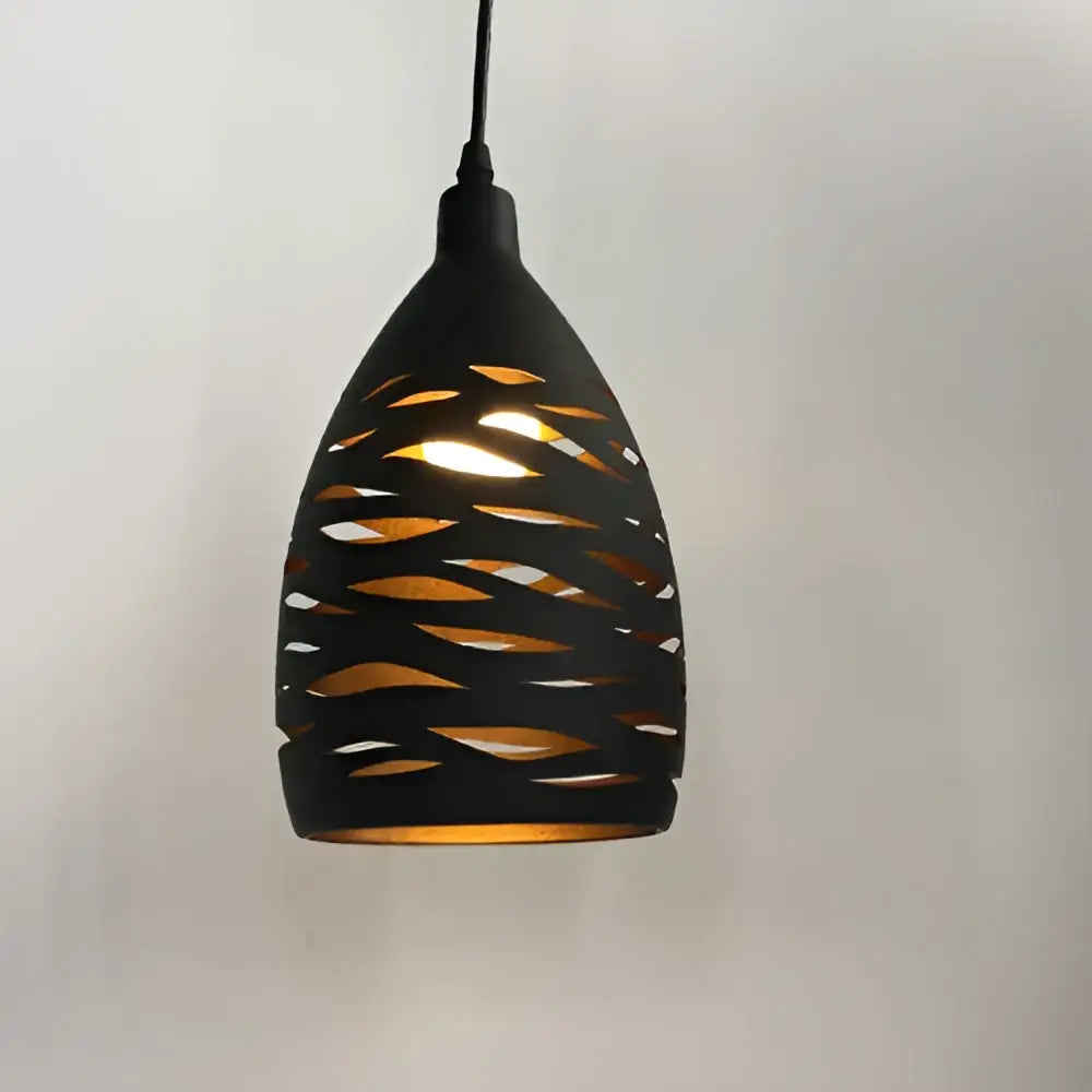 Modern black iron cage pendant light with teardrop shape and intricate cut-out patterns casting warm golden light