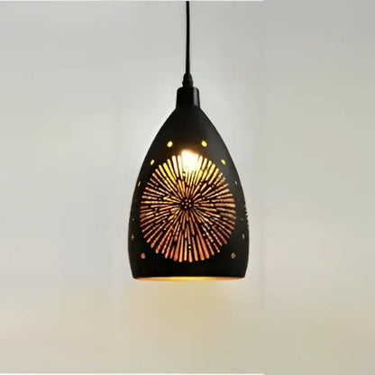 Modern iron cage pendant light featuring a black geometric sunburst cutout design emitting warm golden illumination