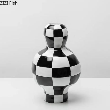 A glossy black and white check ceramic vase with a rounded body and narrow neck for modern room decor decorbites black white
