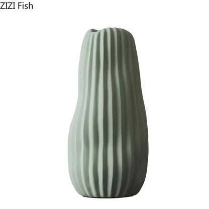 A sleek matte sage green irregular ceramic vase with vertical ridges from decorbites irregular ceramic vase trio decor