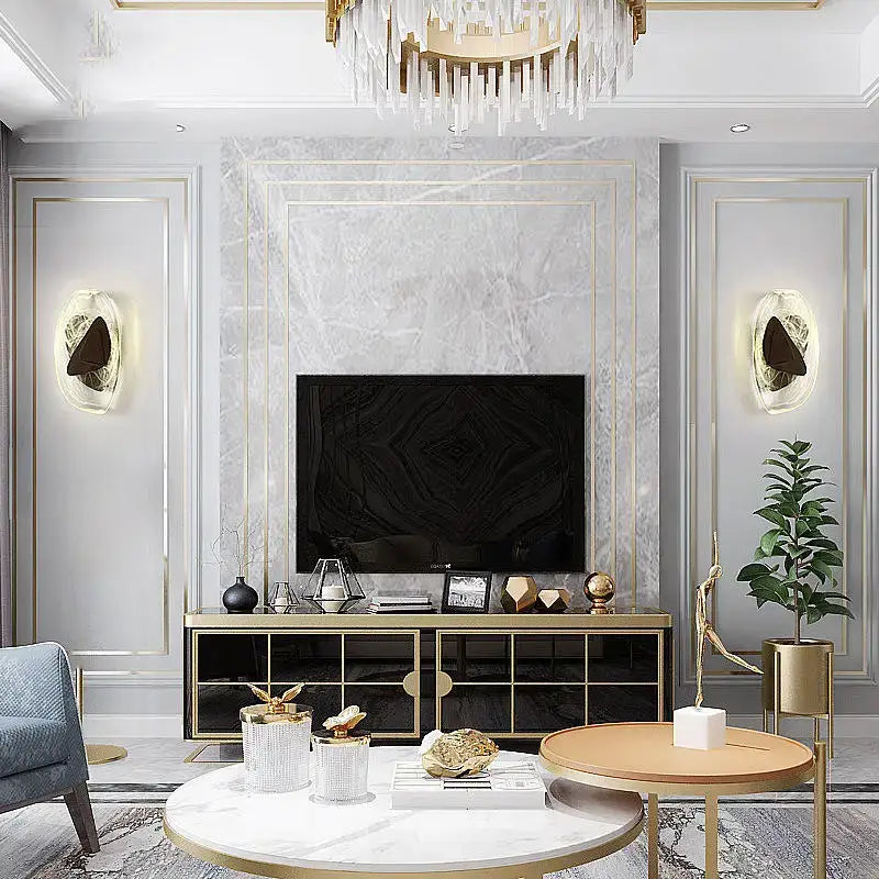 Gold-framed black television mounted on marble wall near modern irregular graphic wall light decorbites irregular graphic sconce