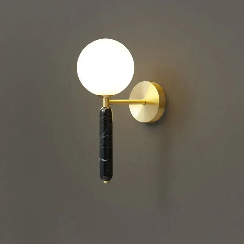 Modern italian green marble wall lamp with black marble stem, spherical frosted glass globe, and gold-toned accents decorbites italian green