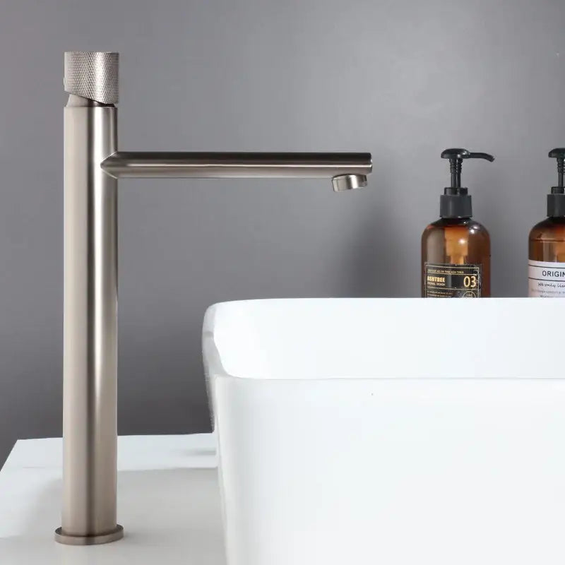 Modern knurled brushed gold basin faucet with a textured cylindrical handle and sleek brushed gold decorbites design