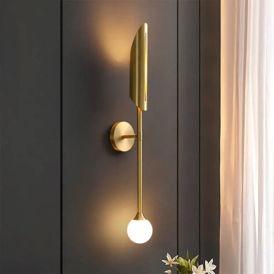 Modern leaf gold led wall lamp features a gold-toned elongated leaf shade and a spherical glass bulb by decorbites gold led