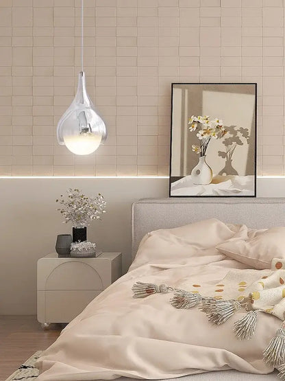 A modern led water droplet ceiling chandelier with a clear glass body and warm glowing bulb for dining room decorbites led water