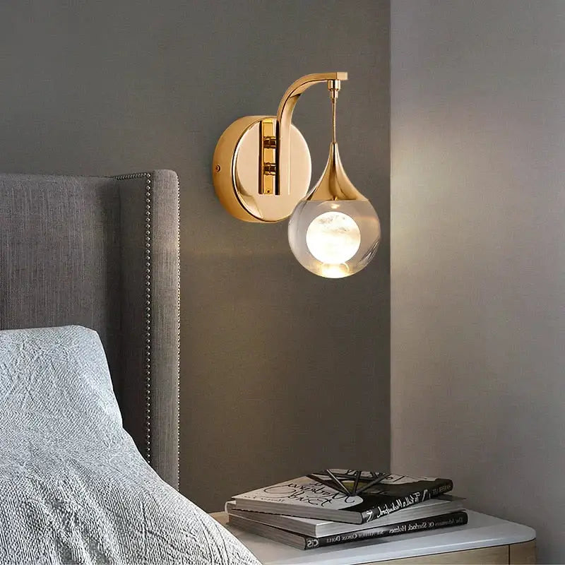 Modern luxurious crystal led wall sconce gold with sleek curved arm and clear glass globe for bedroom lighting