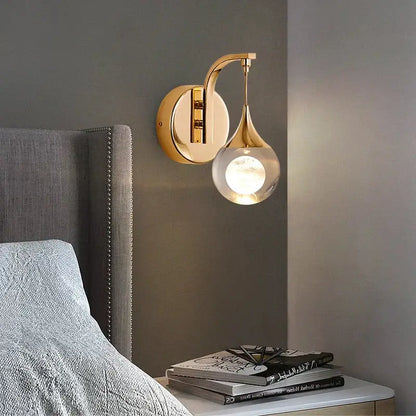 Modern luxurious crystal led wall sconce gold with sleek curved arm and clear glass globe for bedroom lighting