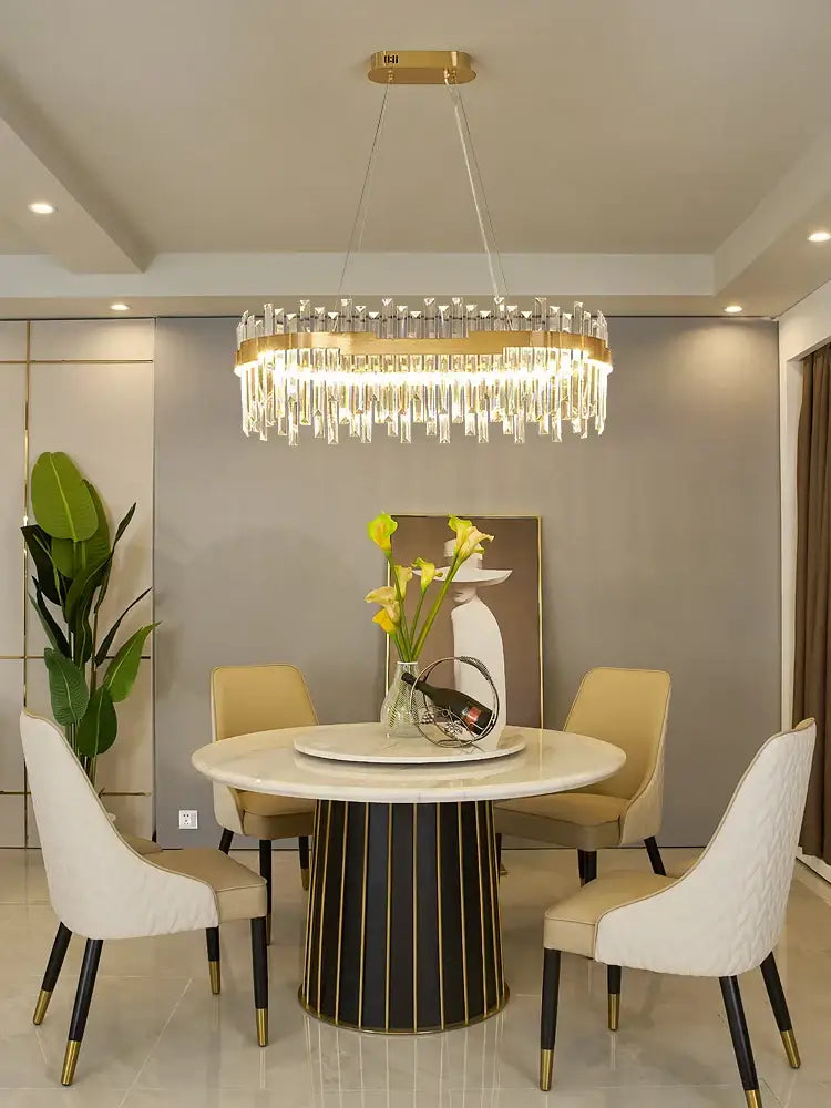 A modern luxury spectrum gold crystal chandelier with a gold crystal frame and clear crystal prisms for dining room