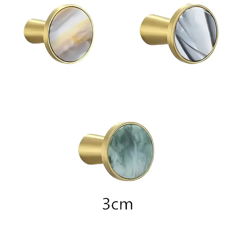 Gold-toned cabinet knobs with marbled white and gray circular inlays for modern brushed gold towel hook decorbites bathroom decor