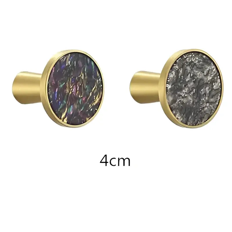 Gold-toned cabinet knobs with oval iridescent stone inlays complement decorbites brushed gold towel hook bathroom decor