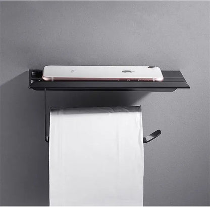 Modern matte black aluminum paper holder with integrated shelf holding a smartphone for black aluminum bathroom decorbites design