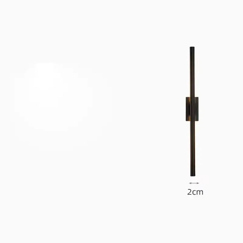 A sleek minimalist wall light with matte black finish and slender vertical brass gold led bar for modern bedroom decorbites