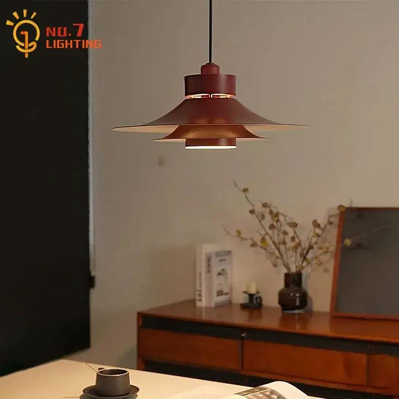 Modern matte black flying saucer pendant light with layered flared design in warm copper finish for dining room decorbites modern flying