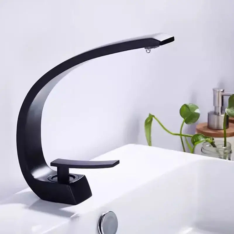 Modern matte black and gold modern basin faucet with sleek curved design in a bathroom basin faucet setup