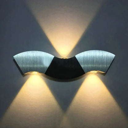 Modern matte black and gray sconce light with aluminum wave design featuring brushed silver and warm white lighting