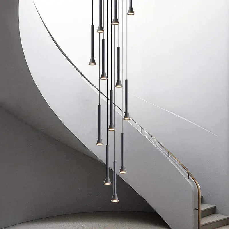 Modern matte black nordic pendant lamp with sleek cylindrical shades hanging above a living room staircase