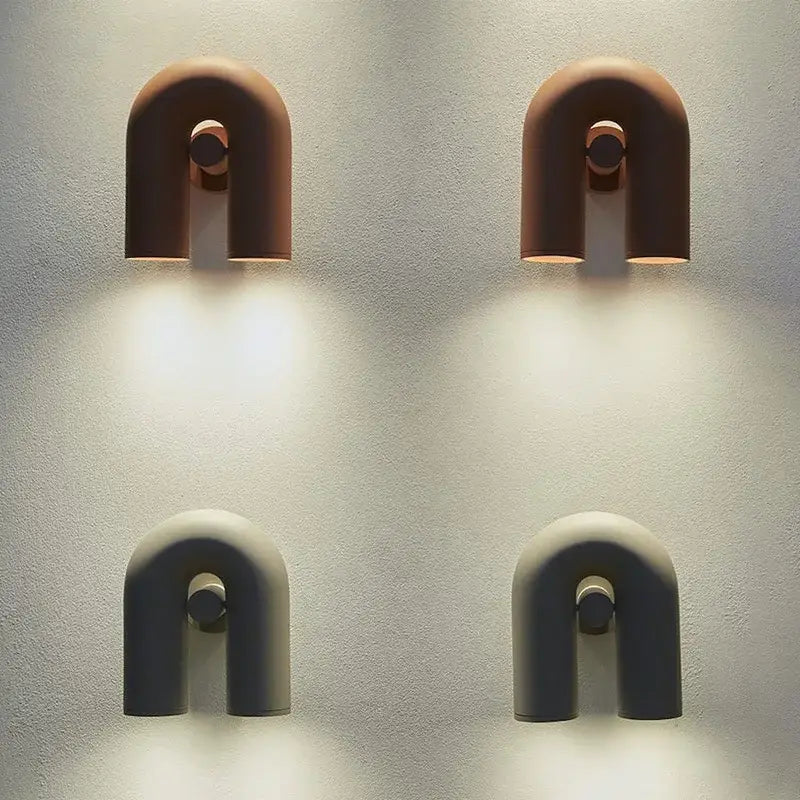 Two minimalist u-shaped wall lamps in terracotta and matte gray ceramic with circular accents for modern tube wall decorbites cirkus tube design