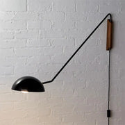 Modern matte black swing arm bedside wall lamp with wooden accent and articulated arm mounted on wall