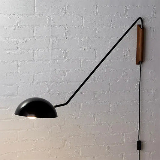 Modern matte black swing arm bedside wall lamp with wooden accent and articulated arm mounted on wall