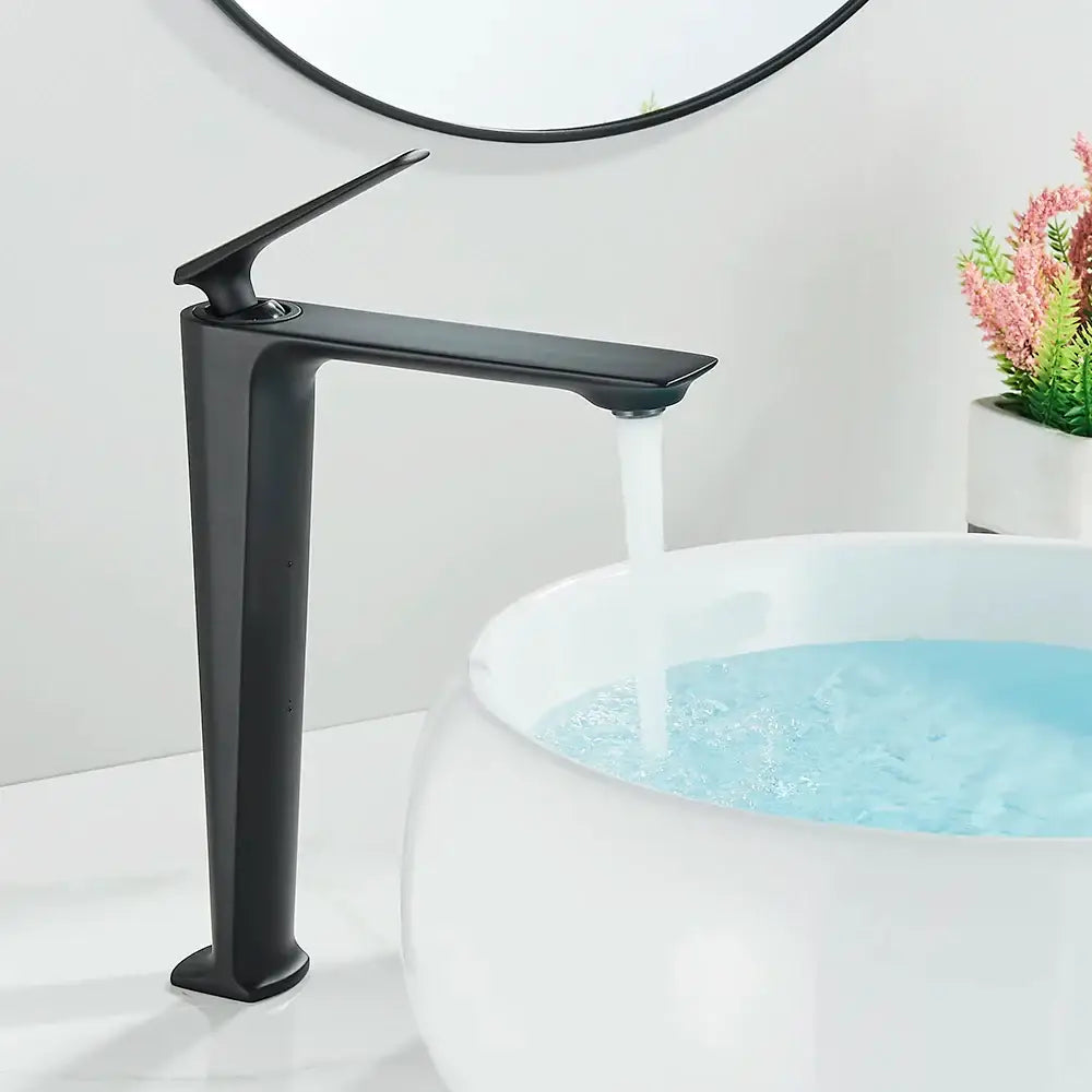 Modern matte black tall basin brass faucet with sleek angular design flowing water into white ceramic basin decorbites black tall