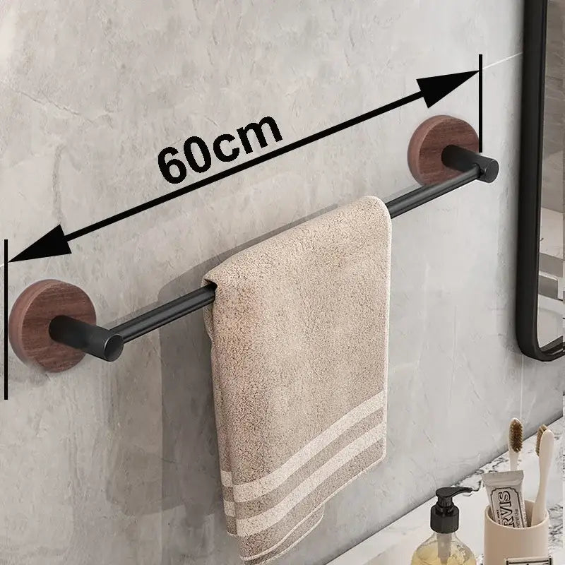 Modern matte black wall mounted towel bar with wood accents holding a beige striped towel on black wall mounted mounts