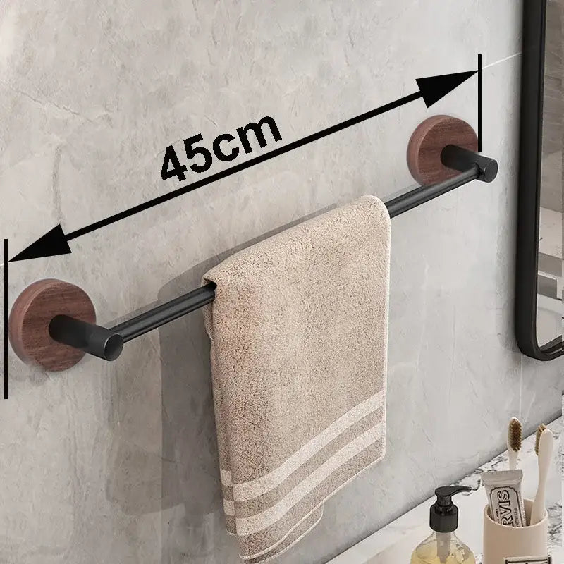 Modern matte black wall mounted towel bar with wooden ends holding a beige striped towel on black wall mounted rack
