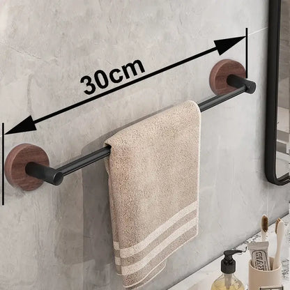 Modern matte black wall mounted towel bar with wood accents holding a beige textured towel in bathroom setting