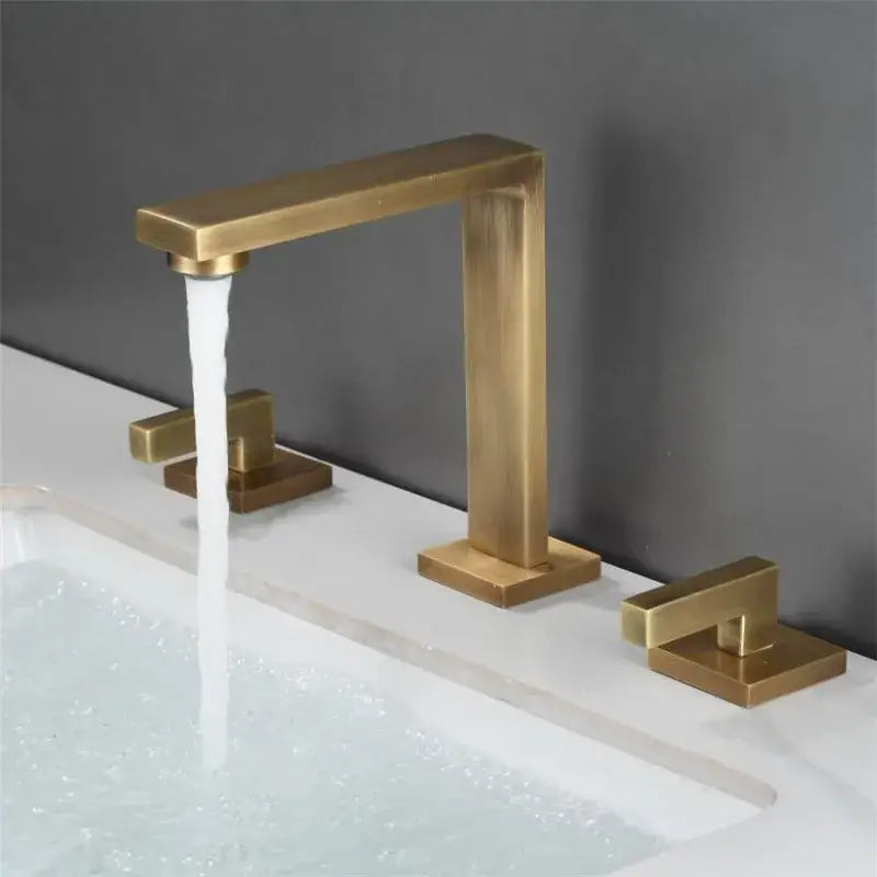 Modern basin faucet with brushed gold finish featuring a sleek rectangular spout and two matching decorbites brushed gold handles