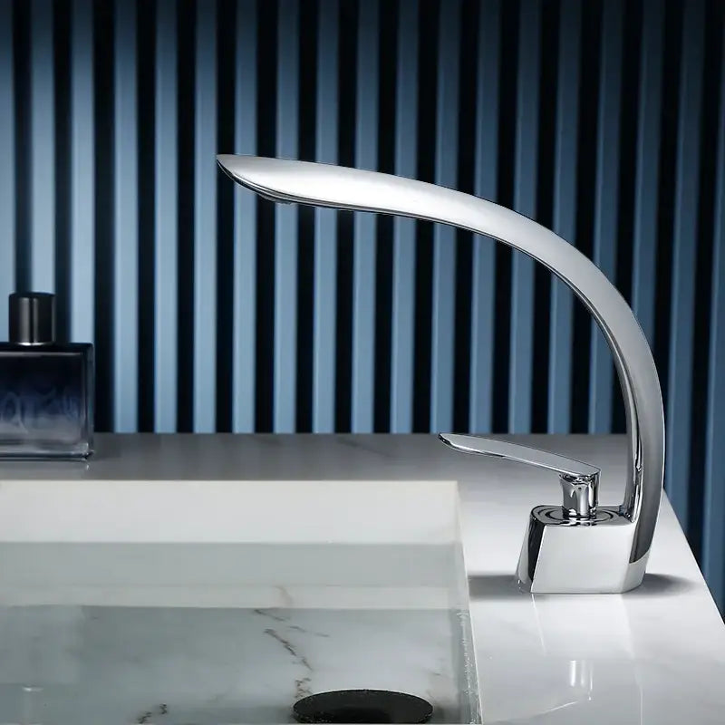 Modern chrome-finished waterfall basin faucet with sleek curved design and single handle mixer for bathroom use