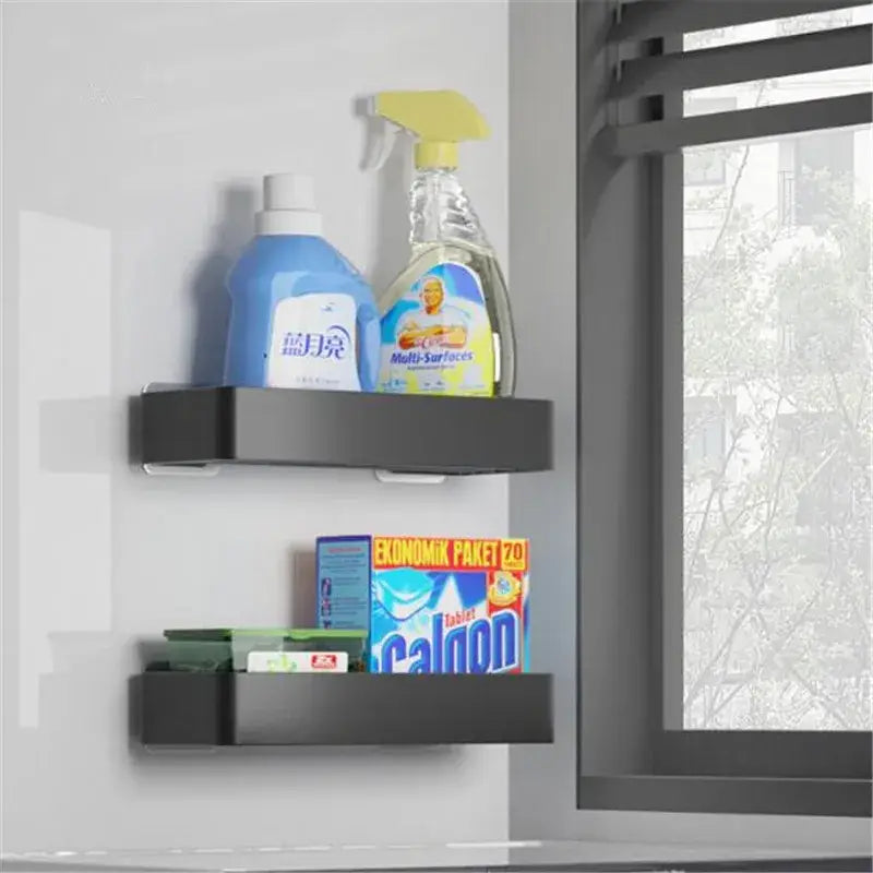Black aluminum bathroom corner shelf mounted on wall holding cleaning supplies in modern matte black and white decorbites design
