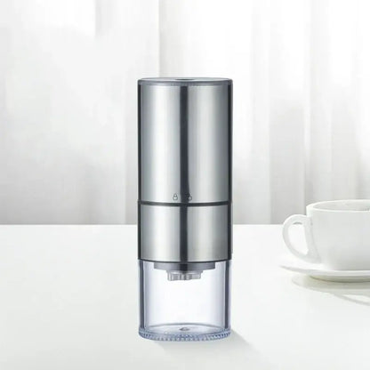 Silver electric bean grinder with transparent base and two-tone metallic body for modern kitchen use