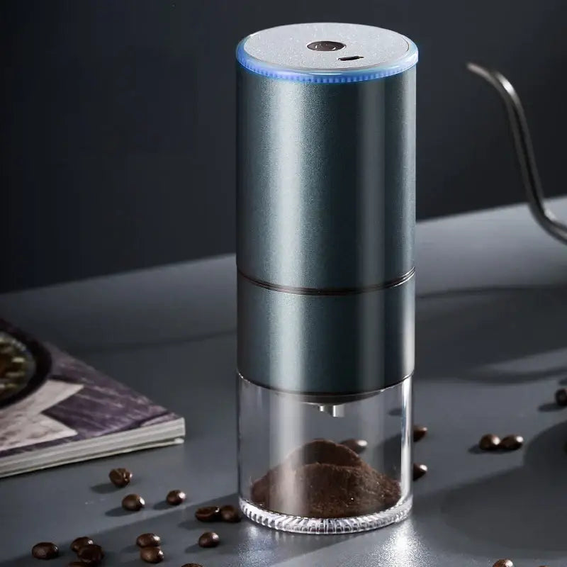 Modern matte gray electric bean grinder with cylindrical body and glass base filled with ground beans for kitchen use