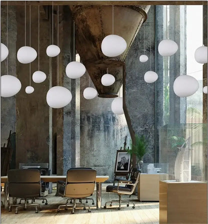 Modern matte white glass pendant light featuring white spherical shades hanging in a kitchen by decorbites gregg glass