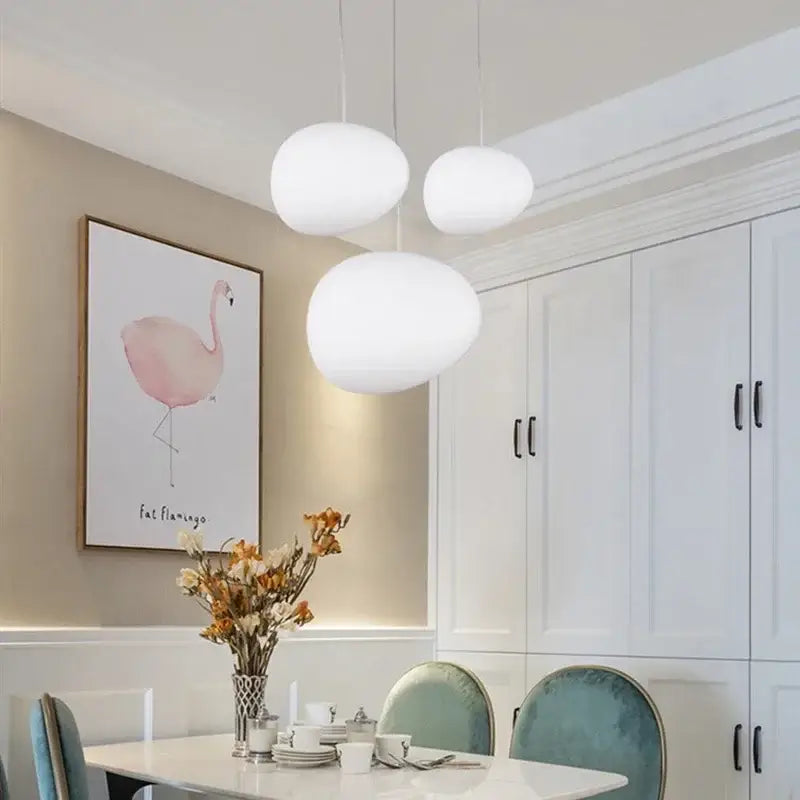 Three white oval-shaped matte glass pendant lights for kitchen and dining room featuring decorbites gregg glass pendant light design