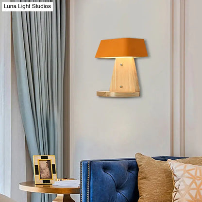 Modern metal light fixture with orange fabric lampshade mounted on wooden backplate with integrated shelf for living room