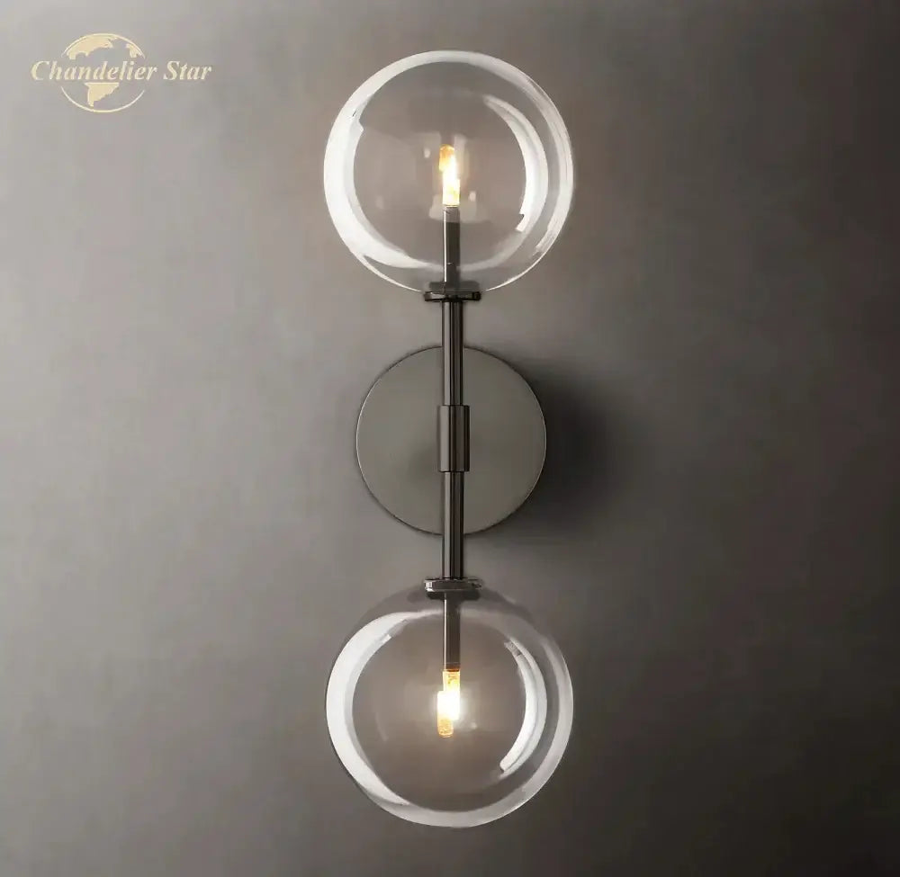Modern metallic wall sconce with two clear glass globes and sleek finish ideal for bedroom lighting
