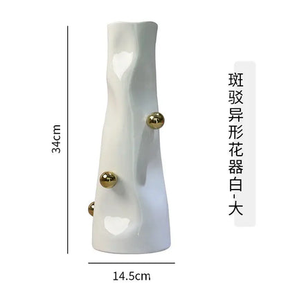 A tall white ceramic decorbites geometric sphere vase with sculpted organic form and three gold sphere accents for living room