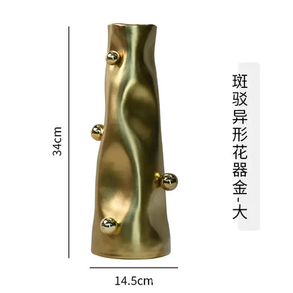 A tall sculpted gold decorbites geometric sphere vase with wavy texture and four metallic spheres for modern living rooms