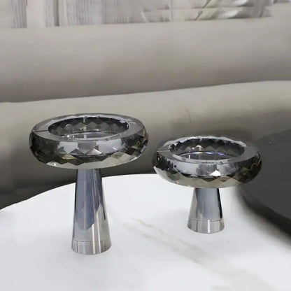 Two sleek faceted crystal candle holders with polished silver bases complement decorbites geometric glass fruit bowl decor