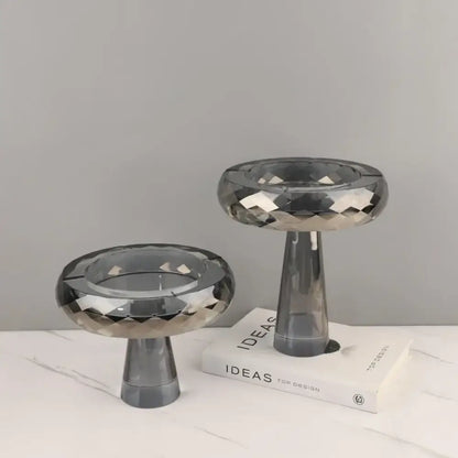 Two sleek dark gray glass candle holders with faceted stems complement decorbites geometric glass fruit bowl dining room stand