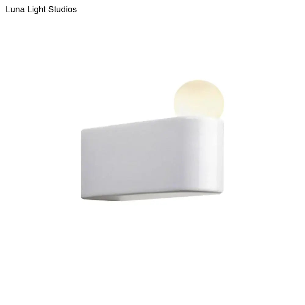 Minimalist white rectangular wall lamp with a softly glowing milk glass ball for small medium bedroom use