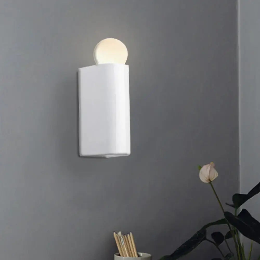 White cylindrical wall lamp with a milk glass spherical light fixture suitable for small medium bedroom spaces
