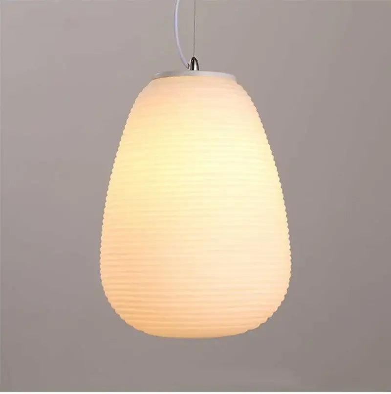 Warm softly glowing modern milky white glass whorls cocoon pendant light with textured ribbed paper shade for dining room