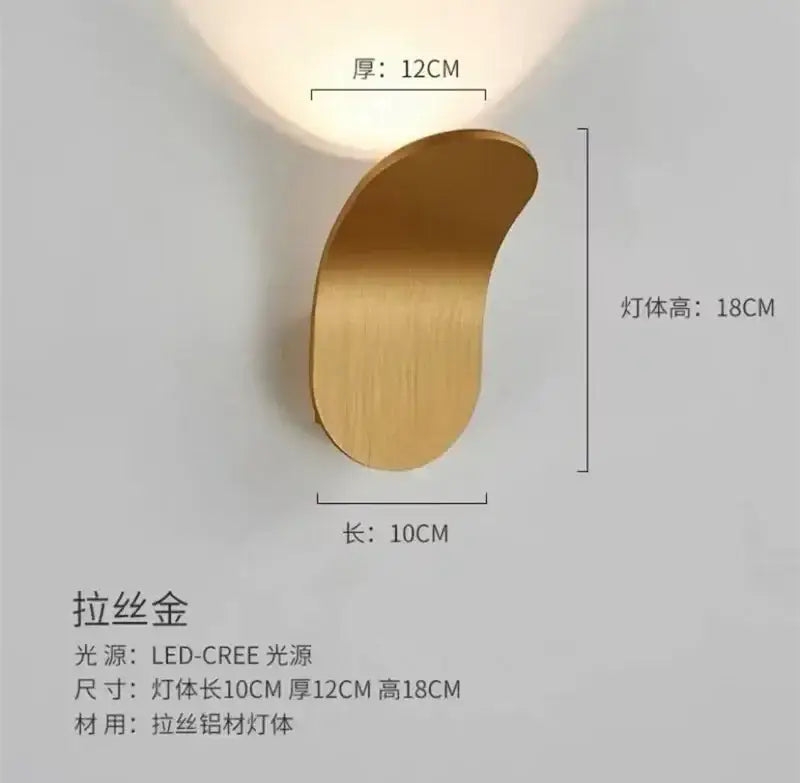 A sleek brushed gold wall light with modern crescent design and integrated adjustable cob led for bedroom decorbites