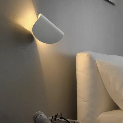 A sleek white minimalist wall lamp with curved art decor rotating design casting warm light for bedroom decorbites