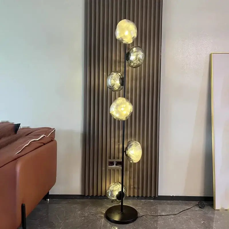 Modern minimalist black floor lamp with five glowing glass shade led orbs on a sleek metal pole for home decor