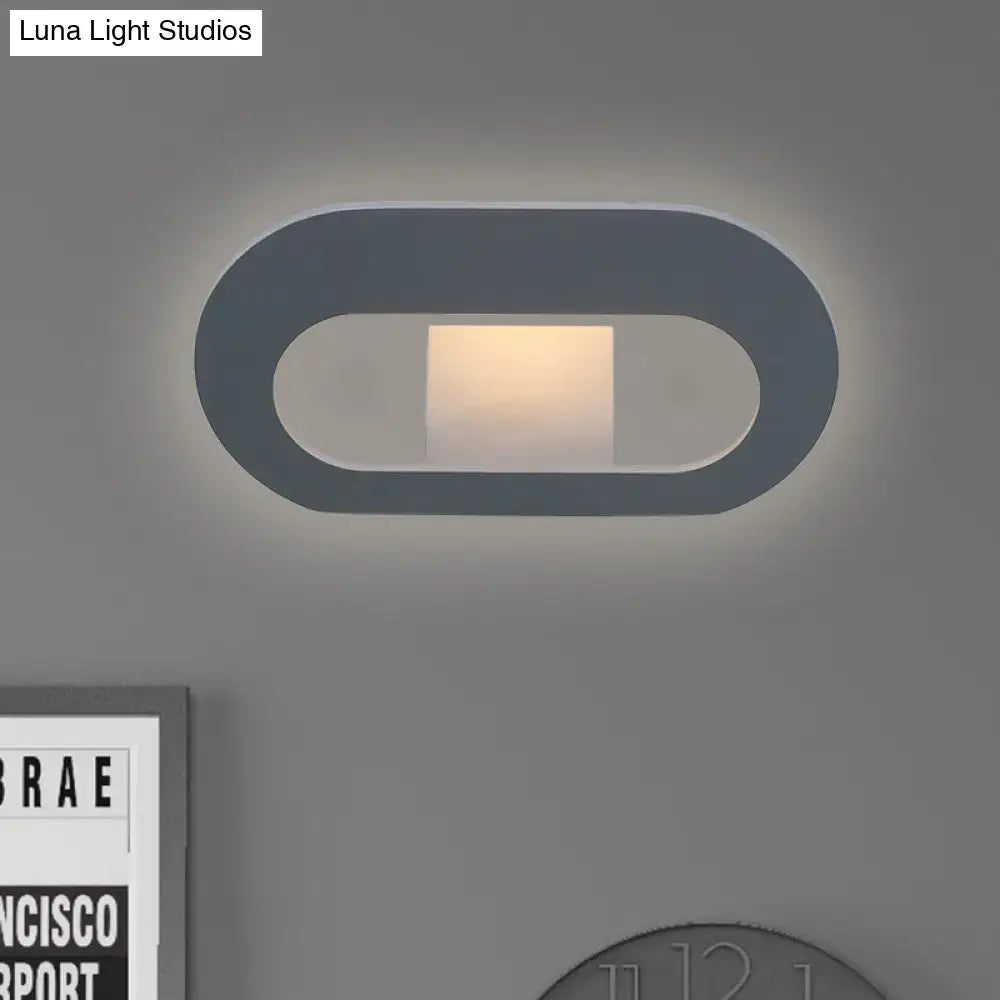 Modern minimalist wall lamp with a dark gray oval shade and warm diffused lighting for bedroom use and max bulb wattage