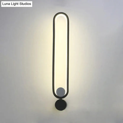 Modern minimalist black led wall sconce with sleek oval design providing warm ambient lighting for bedroom and living room