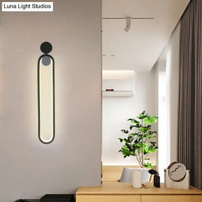 Modern minimalist black led wall sconce with sleek oval light panel and circular accents for bedroom and living room