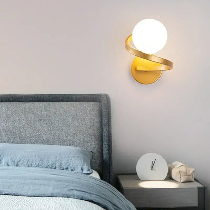 Gold-toned wall lamp with frosted glass ball and curved metallic arms modern minimalist led wall lamp for bedroom